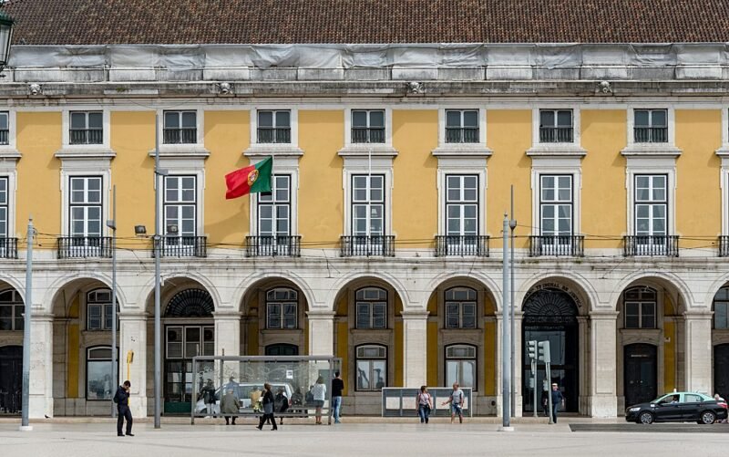 Yellow building flying a Portuguese flag at Praca do Comercio, Lisbon